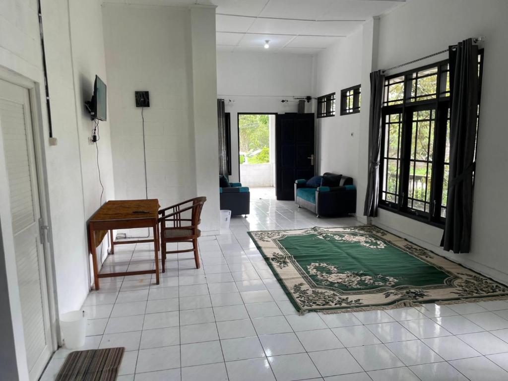 uma sala de estar com uma mesa e um sofá em Sejahtera Homestay em Cangkringan