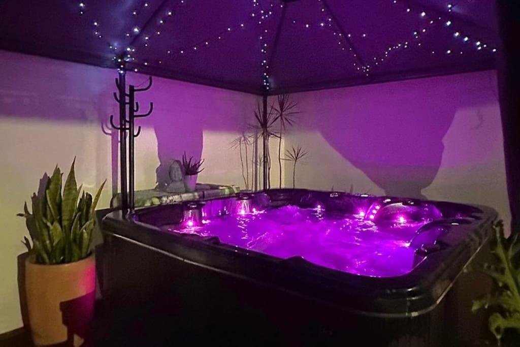 een paarse hot tub in een kamer met planten bij L'escale idéale in Le Tampon