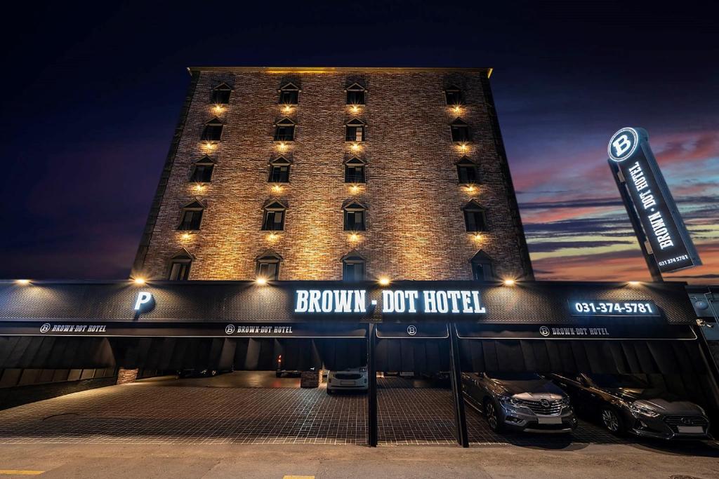 un edificio con coches estacionados frente a él en Brown Dot Hotel Osan, en Osan