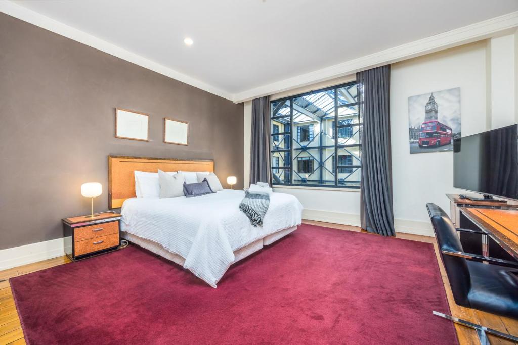 een slaapkamer met een groot bed en een groot raam bij Charming Studio Apartment in Auckland Central in Auckland