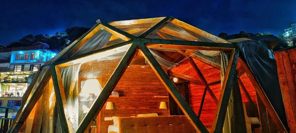 uma grande casa de madeira com um telhado de vidro em Starlit Dome Mcleodganj em McLeod Ganj