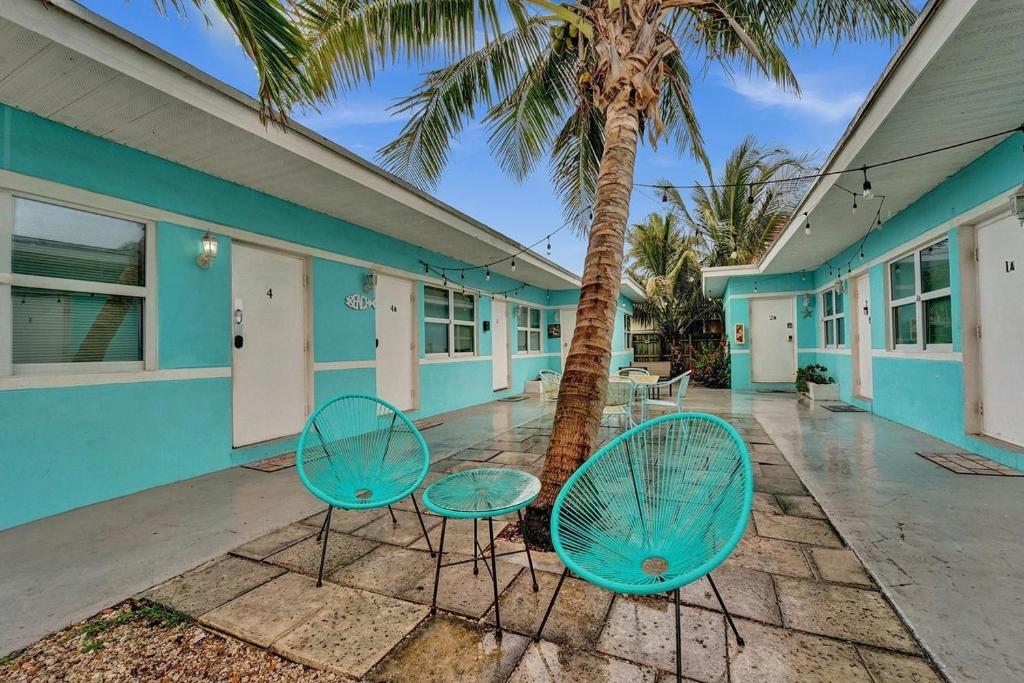 two blue chairs in front of a building with a palm tree at Hollywood Broadwalk Beach Walk Holiday Retreat in Hollywood