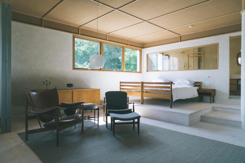 1 dormitorio con 1 cama, mesa y sillas en haluta hotelli still en Karuizawa