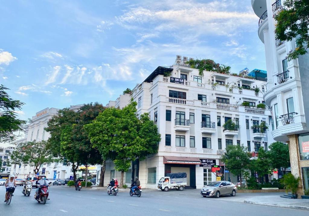 un grupo de personas en motocicleta por una calle de la ciudad en In Le Hotel & Apartments, en Hai Phong