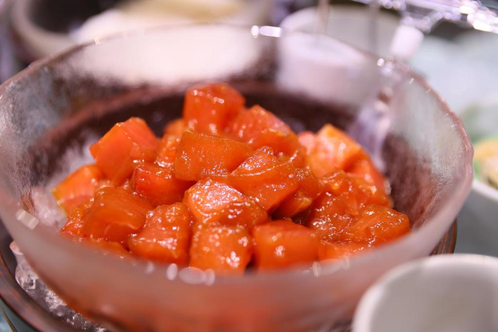 a bowl of orange fruit is being cooked at Dormy Inn Kanazawa Natural Hot Spring in Kanazawa