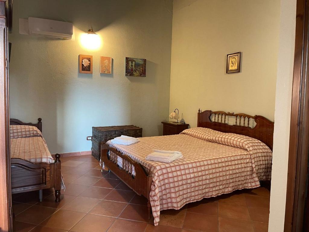sypialnia z 2 łóżkami i krzesłem w obiekcie Ponte Calatrasi Agriturismo w mieście Roccamena