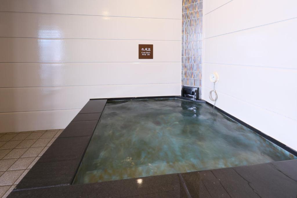 a hot tub in the corner of a room at Dormy Inn Kanazawa Natural Hot Spring in Kanazawa
