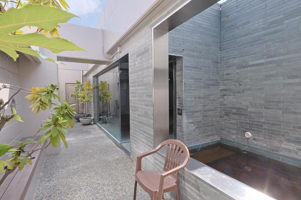 a chair sits in the corner of a house at Dormy Inn Kanazawa Natural Hot Spring in Kanazawa