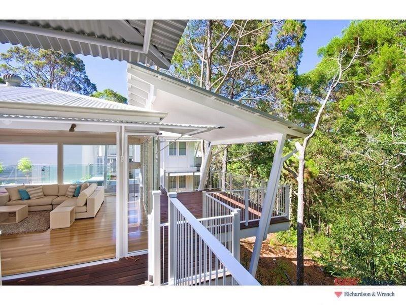 a porch of a house with a couch and a deck at 14 Little Cove Road, Little Cove in Noosa Heads