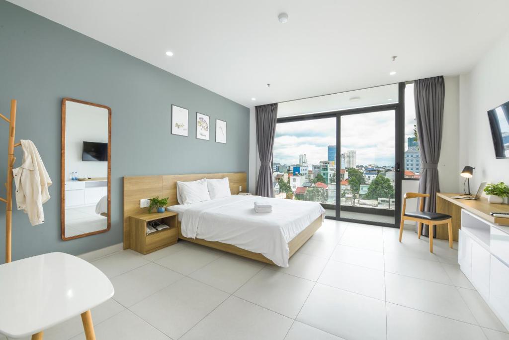 LP rental - Minimalist Studio Apartments في Thu Dau Mot: غرفة نوم بسرير ونافذة كبيرة