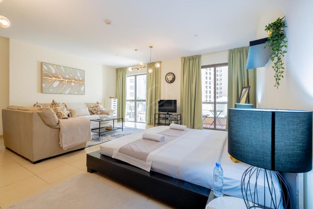 1 dormitorio grande con 1 cama y 1 sofá en Perfect studio near the beach JBR, en Dubái