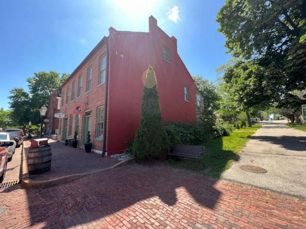 ein rotes Gebäude mit einem Baum an der Seite in der Unterkunft Main Street Living! 2 Bedroom Unit right On Main! in St. Charles