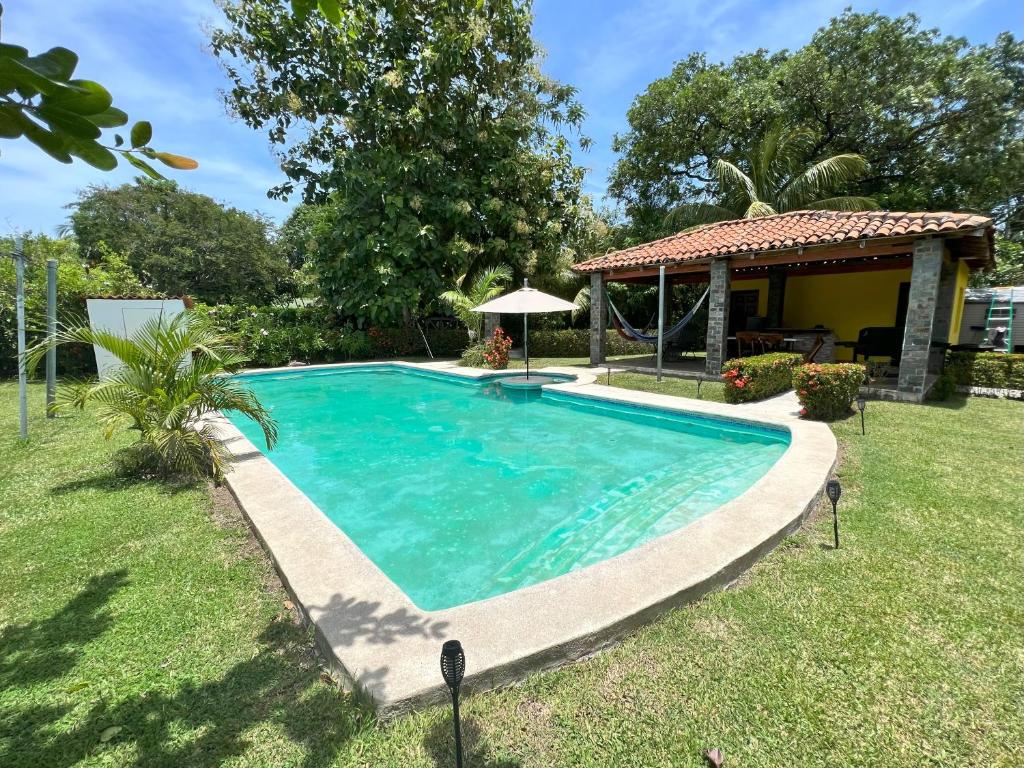 a swimming pool in the yard of a house at Las Veraneras Villa - Pet Friendly in Acajutla