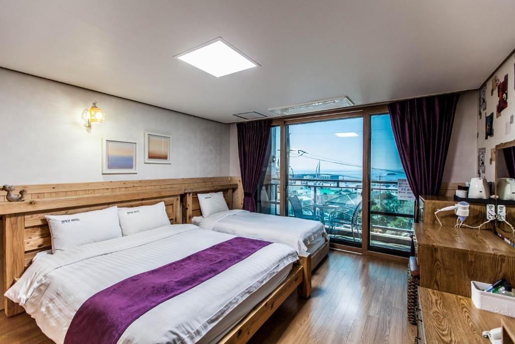 Postel nebo postele na pokoji v ubytování Cheonjiyeon Hotel