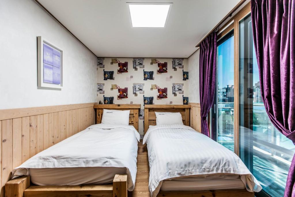 Postel nebo postele na pokoji v ubytování Cheonjiyeon Hotel