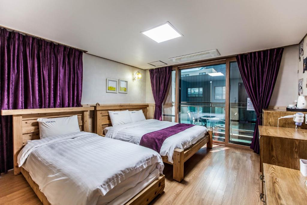 Postel nebo postele na pokoji v ubytování Cheonjiyeon Hotel