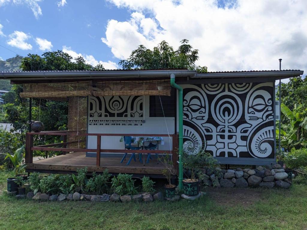 ein Haus mit einer Terrasse im Gras in der Unterkunft Noho Mai in Nuku Hiva
