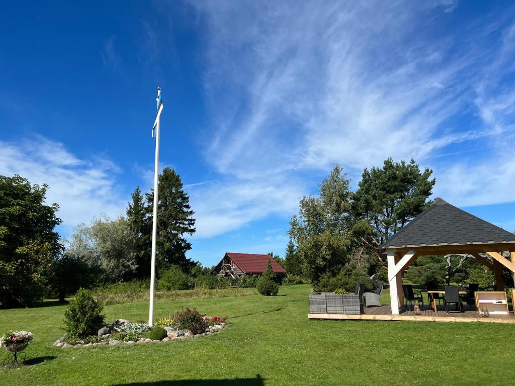 a flag pole in a yard with a gazebo at Suurekivi külalistemaja in Reigi