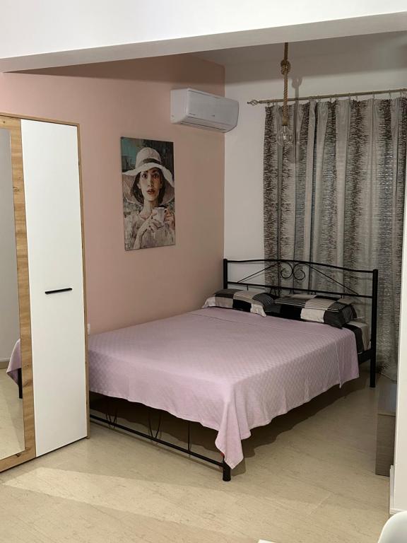 a bedroom with a bed and a picture of a woman at SeaSideRooms in Ierápetra