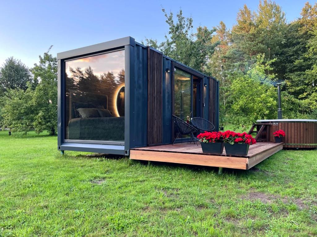 a black tiny house sitting on the grass at Reborn Cabins in Pabaži