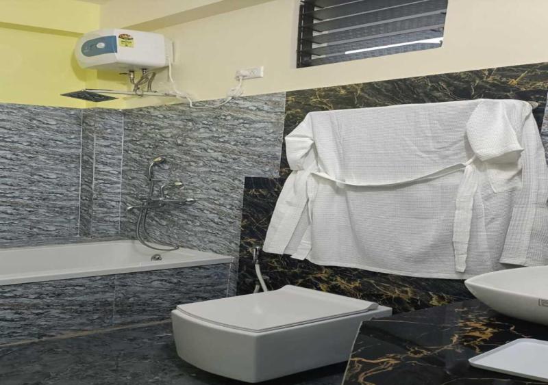 uma casa de banho com um WC branco e um lavatório. em ST Apple Beach Resort Mandarmani em Mandarmoni