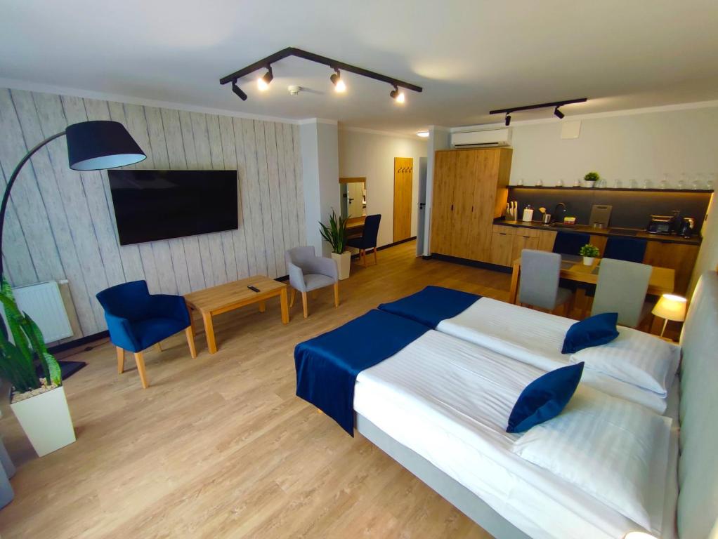 sypialnia z dużym łóżkiem i salonem w obiekcie Apartamenty Wielka Odrzańska Centrum w Szczecinie