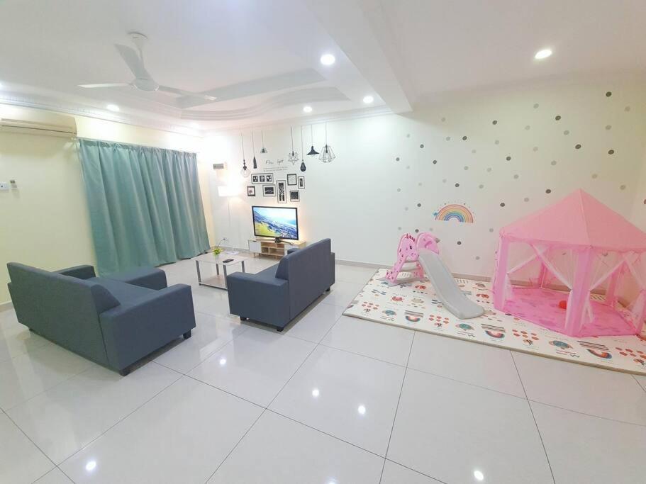 - un salon avec un lit rose et une télévision dans l'établissement 6243 Sbn Jaya # U Homestay, à Seremban