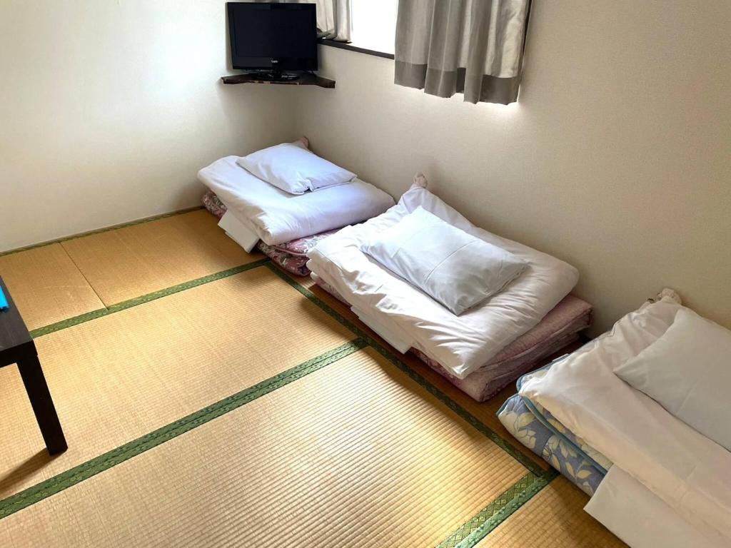 2 Betten in einer Ecke eines Zimmers in der Unterkunft Southern Village Okinawa - Vacation STAY 09978v in Kishaba
