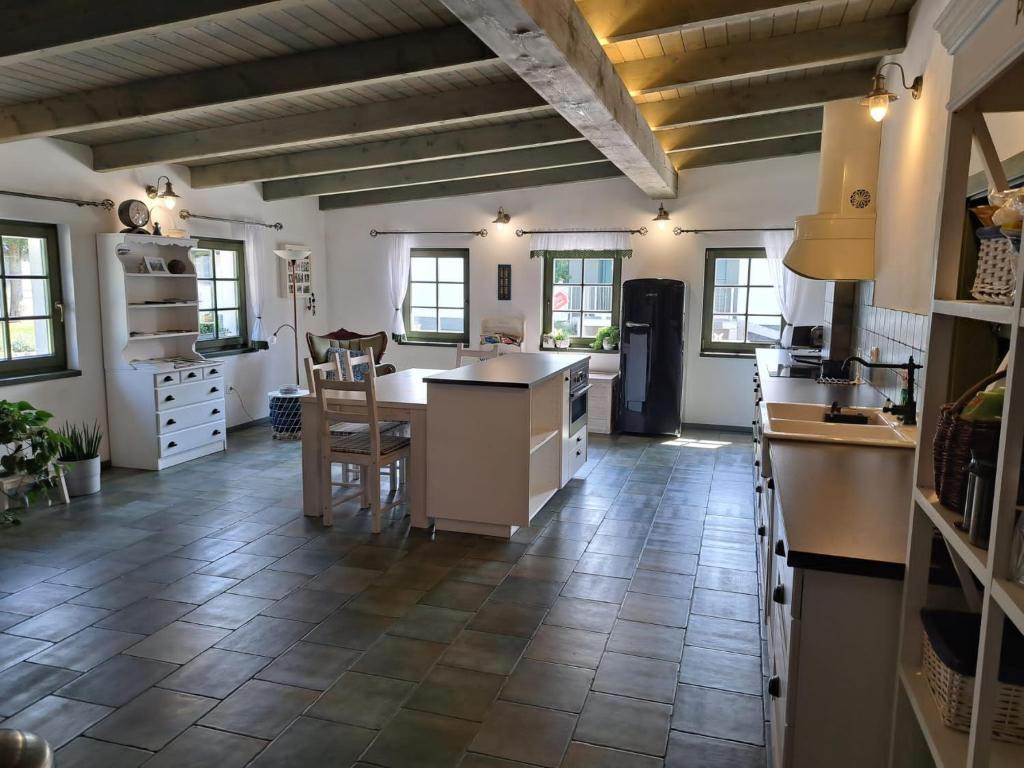 a large kitchen with a tile floor and white cabinets at Penzion U vinaře in Velké Bílovice