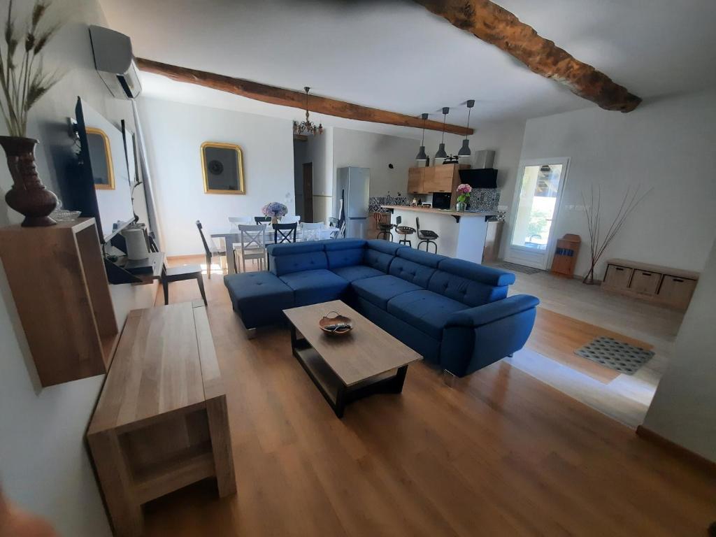 a living room with a blue couch and a table at Gîte Brequat - Pyrénées Atlantique in Lestelle-Bétharram