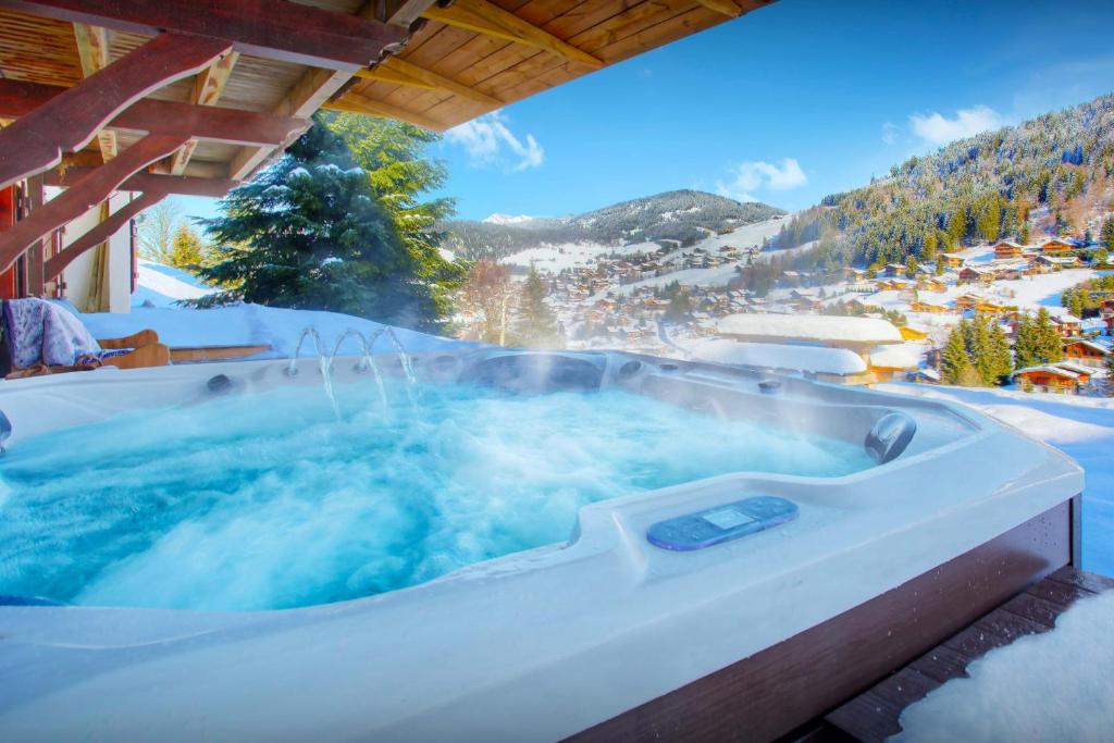 a jacuzzi tub with snow on the ground at Chalet Batieu - OVO Network in La Clusaz