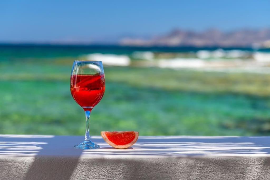 una copa de vino y una pieza de fruta en una mesa en Esperanza Boathouse, en Mandrakia