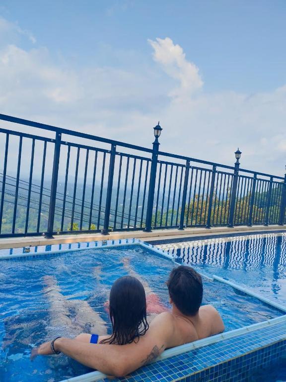a man and woman sitting in a swimming pool at Hotel Sky Gate kandy in Kandy