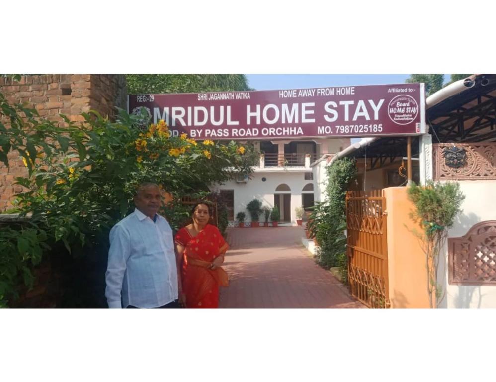 a man and a woman standing in front of a house at Mridul Homestay Orchha, Madhya Pradesh in Orchha