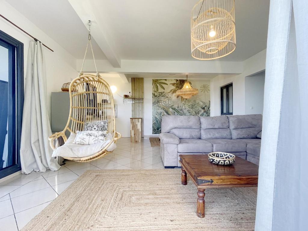 a living room with a couch and a swing at L'Air Sauvage * * * Bassin de Manapany in Saint-Joseph