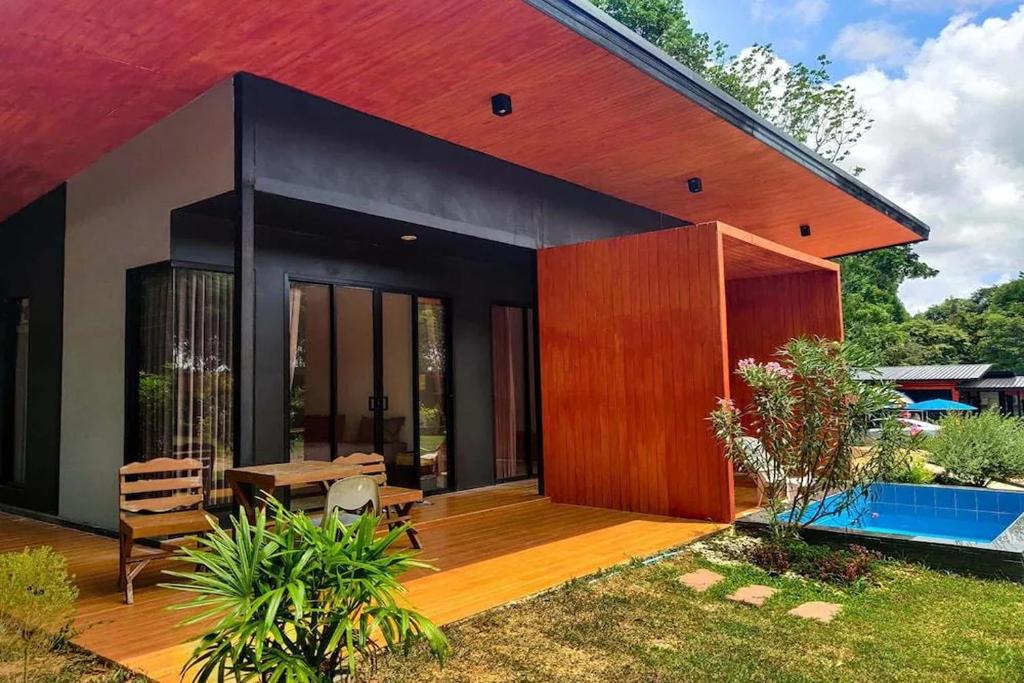 a modern house with a patio and a pool at Forest Hill Resort in Chanthaburi