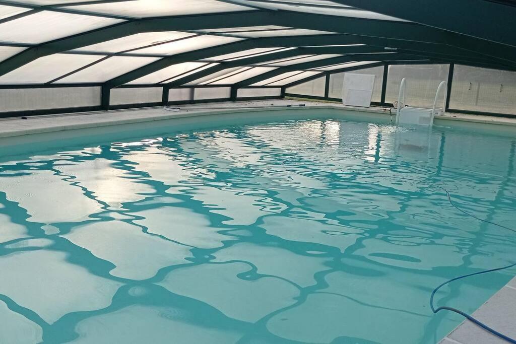 une piscine intérieure avec toit dans l'établissement Maison de campagne avec piscine privée, à Le Guédéniau