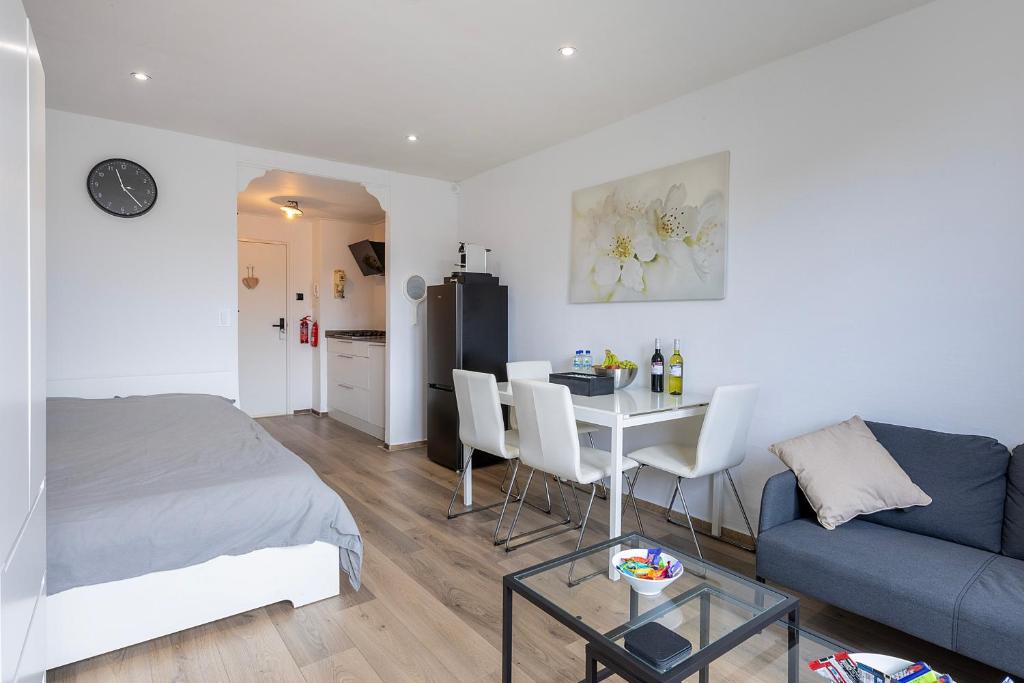 1 dormitorio con cama, mesa y sofá en Sunny Studio - Only 5-Min Walk to Sea & Dunes, en Wijk aan Zee