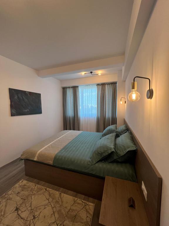 een kleine slaapkamer met een bed en een raam bij Green Residence in Suceava