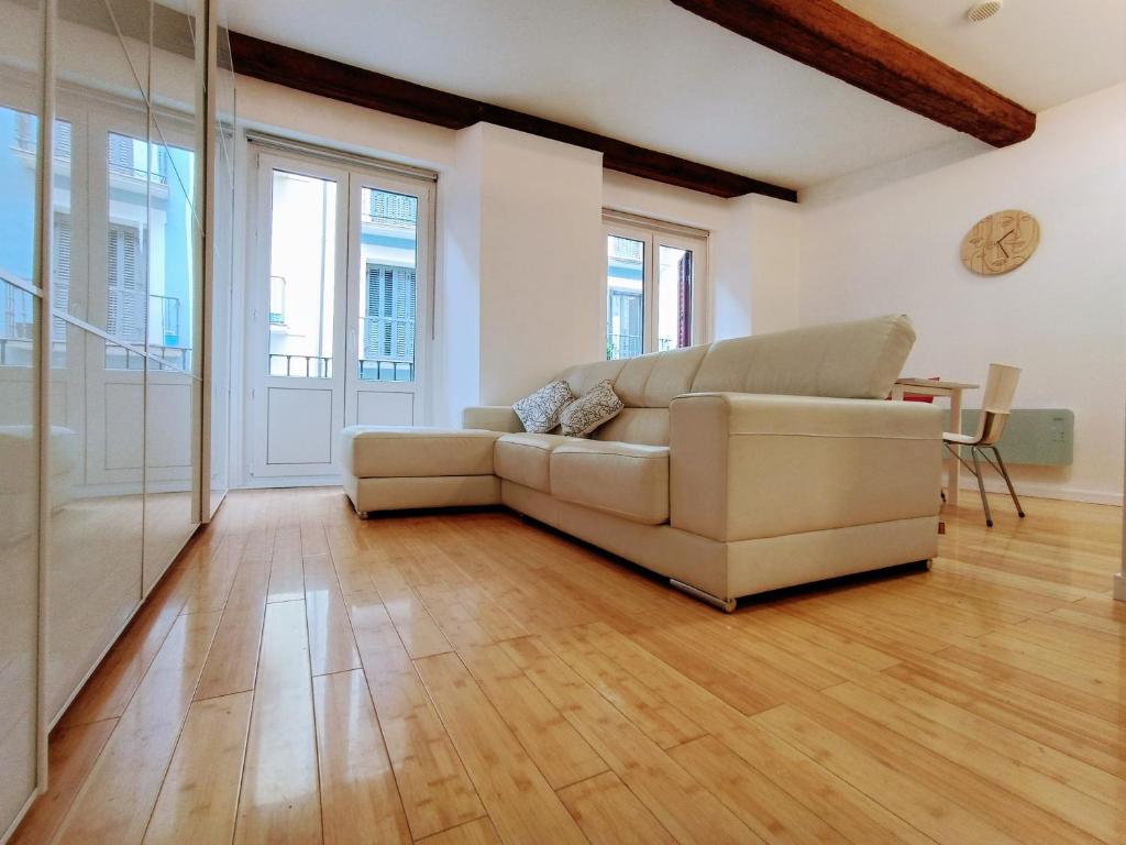 uma sala de estar com um sofá e pisos em madeira em Céntrico y con encanto 'El Mirador de Chapitela' em Pamplona