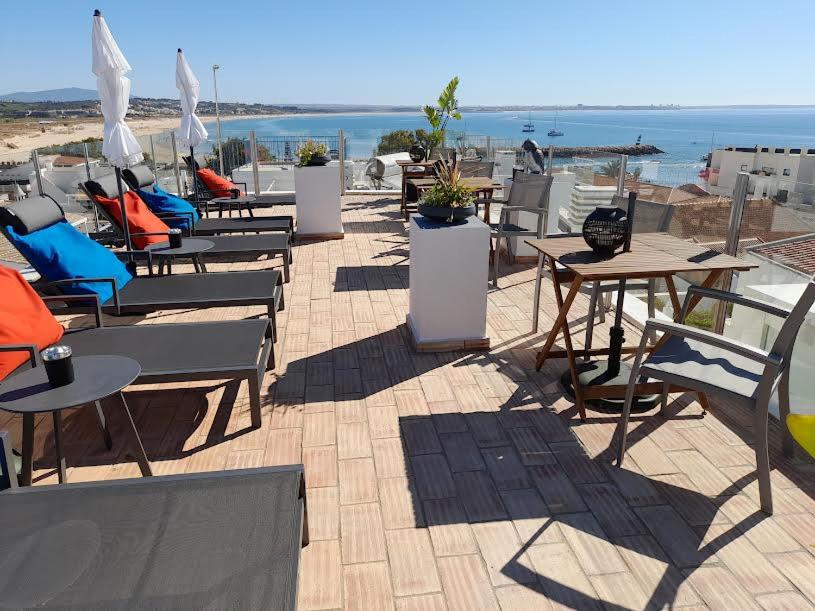 un patio con mesas y sillas y vistas al océano en Casa Paula Apartments, en Lagos