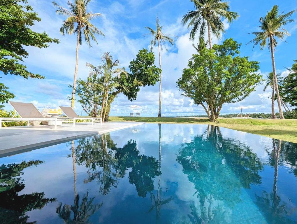 a pool of water with palm trees in the background at Kalinaw Resort in General Luna