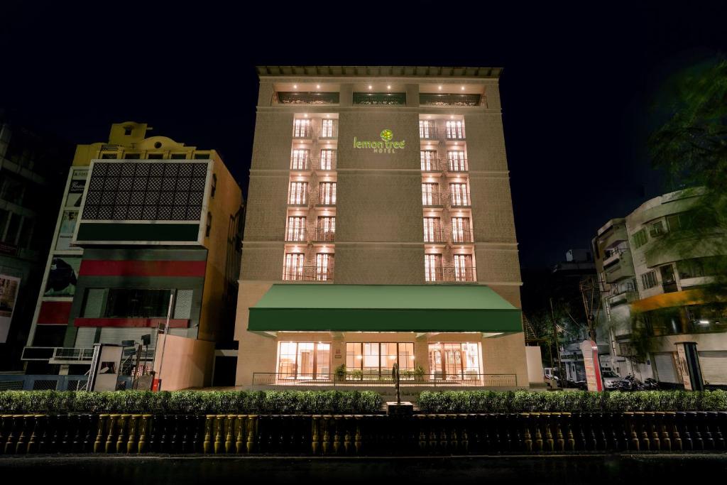 wysoki budynek z znakiem na górze w obiekcie Lemon Tree Hotel, Rajkot w mieście Radźkot