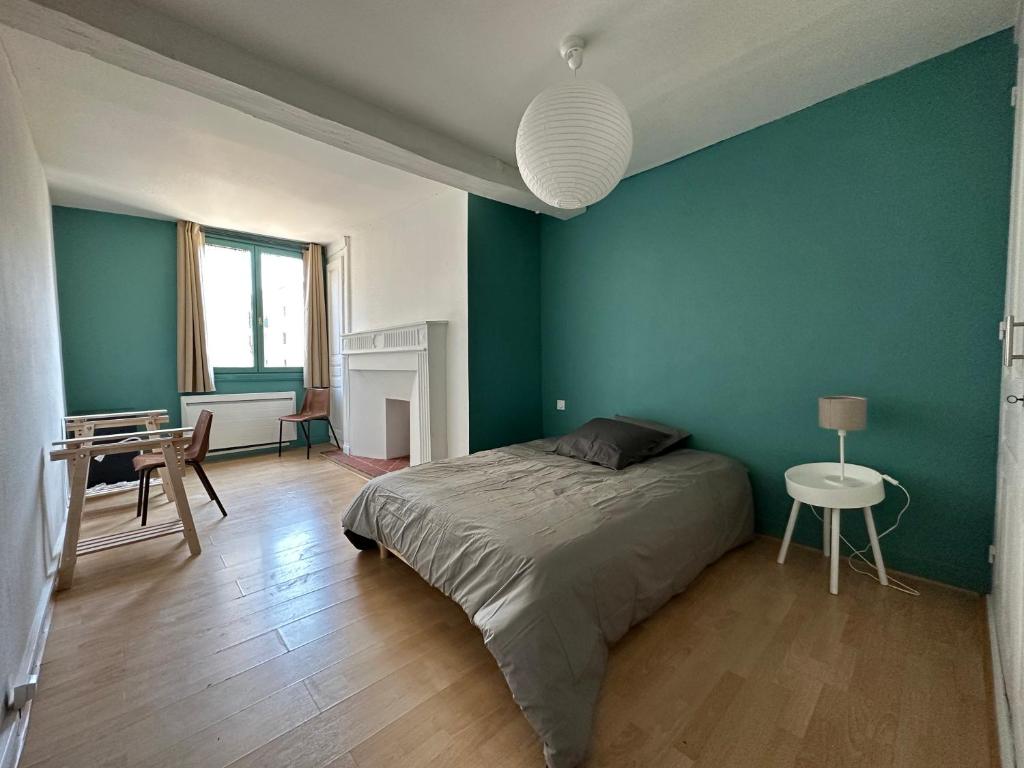 トロワにあるChambre dans maison originale en centre villeの緑の壁のベッドルーム(ベッド1台、テーブル付)