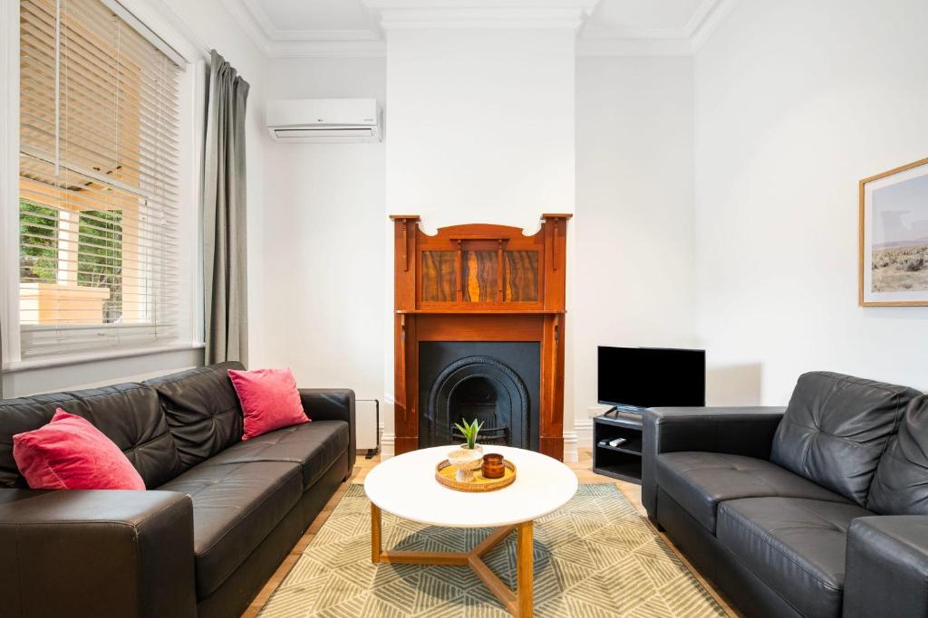 a living room with two couches and a fireplace at Beachside Cottage Glenelg Sth in Glenelg