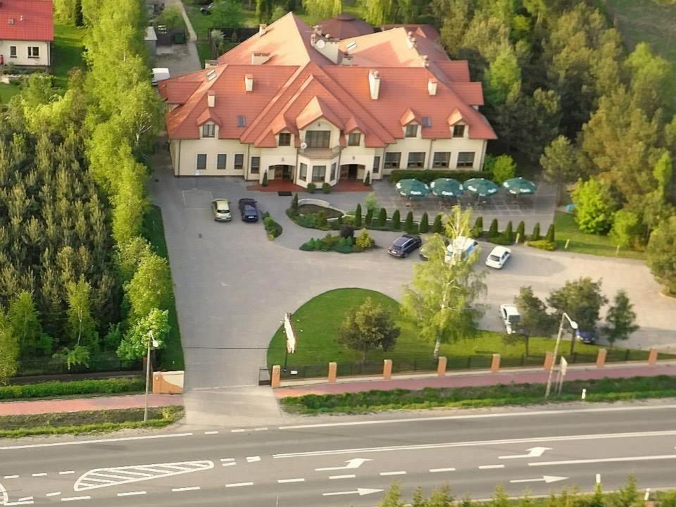 Maxima Hotel في Wolanów: منزل كبير وامامه موقف سيارات