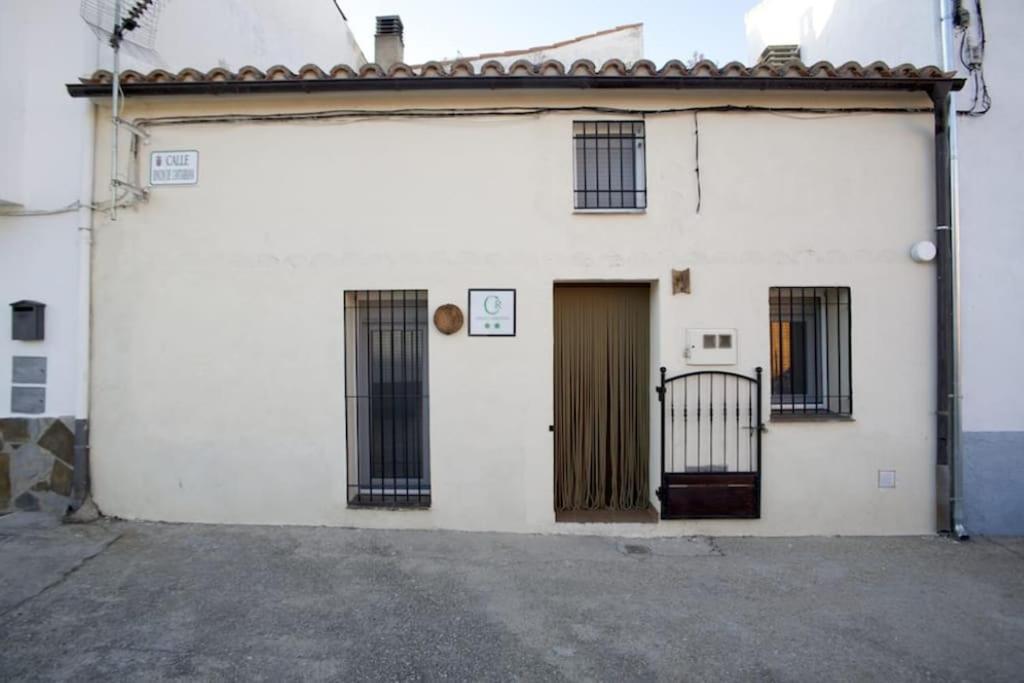 a white building with a door and windows at La Casina de Carcaboso in Carcaboso