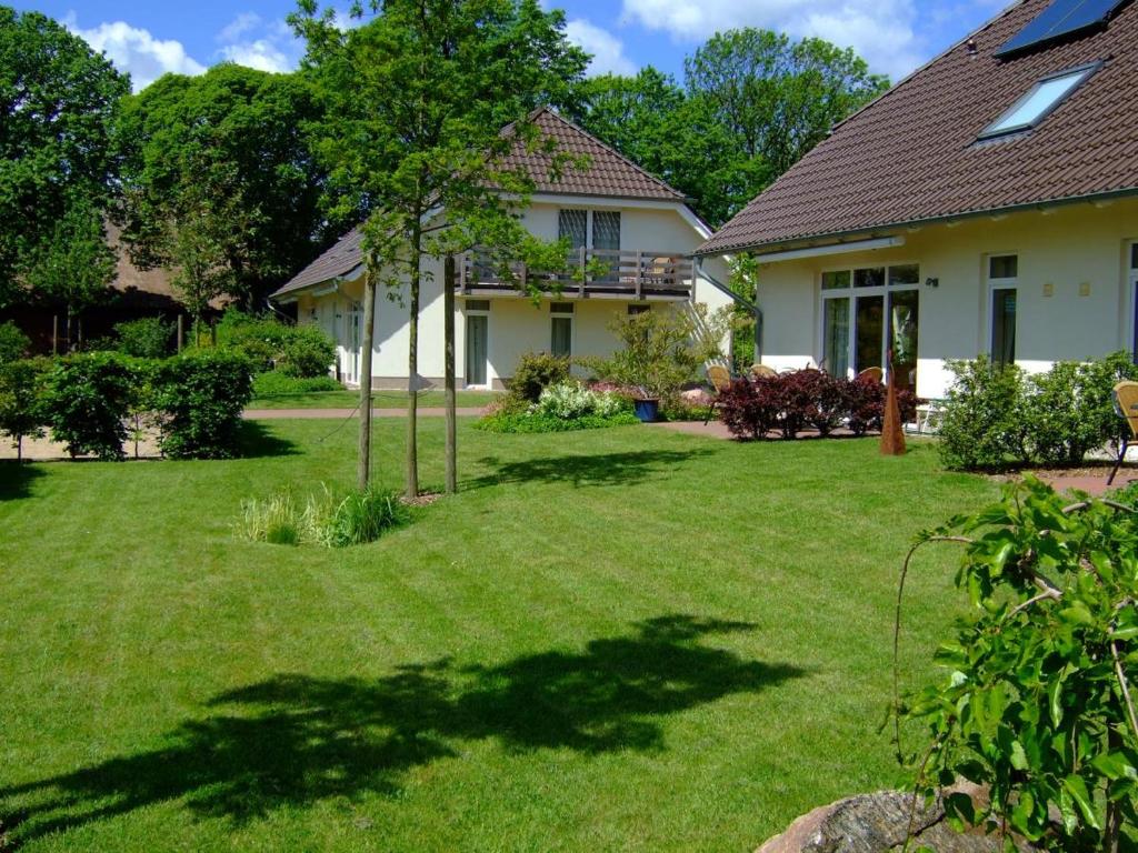 una casa con un patio con césped verde en 4 Sterne Apartment Kap Arkona mit Balkon, en Lobbe