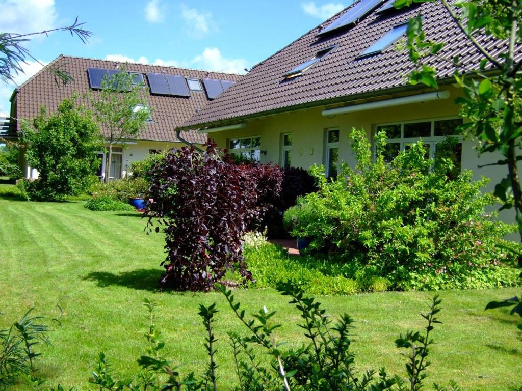 une maison avec une brousse dans la cour dans l'établissement 4 Sterne Apartment Dünensand Sauna und Terasse in Südwestlage, à Lobbe
