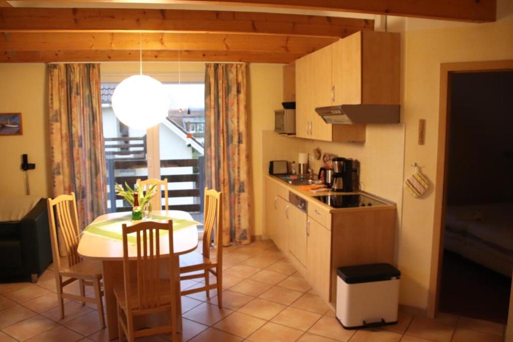 cocina y comedor con mesa, mesa y sillas en 4 Sterne Apartment Greifswalder Oie mit Balkon, en Lobbe